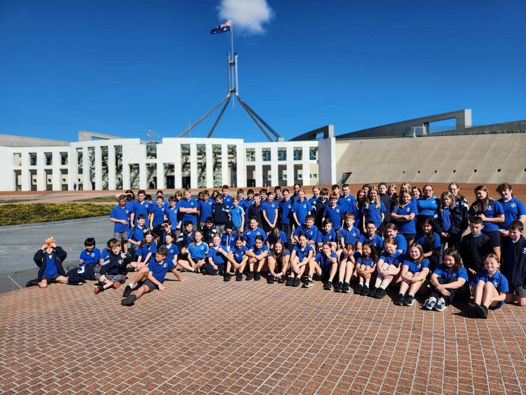 A group of students in Canberra sitting at the front of Parliament House