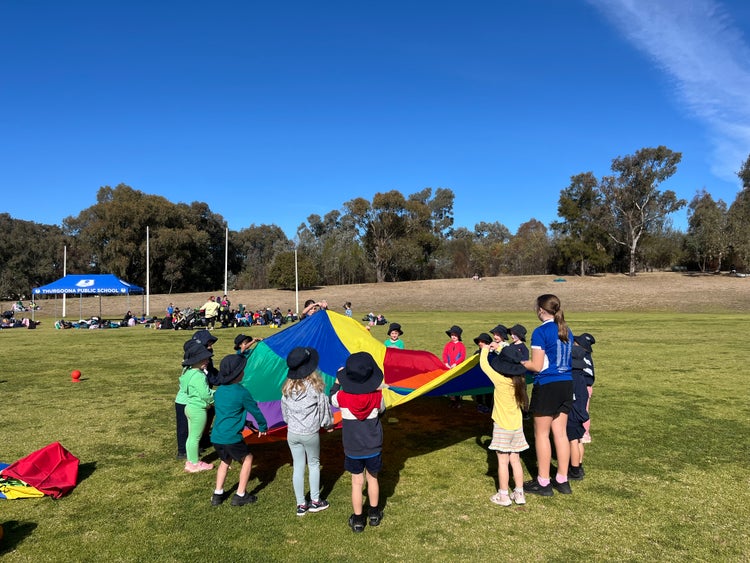 Children on the oval holding a parachute