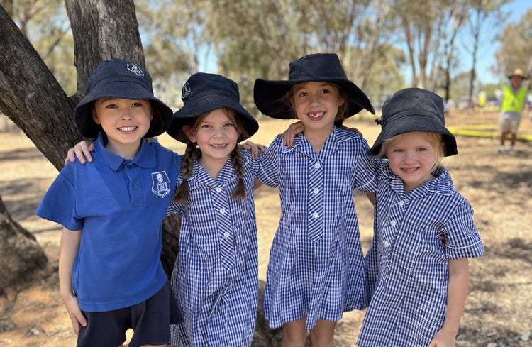 Four students posing for a photo in the playground