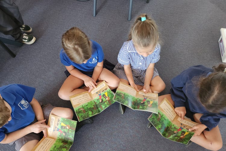 Students sitting on the floor reading in class