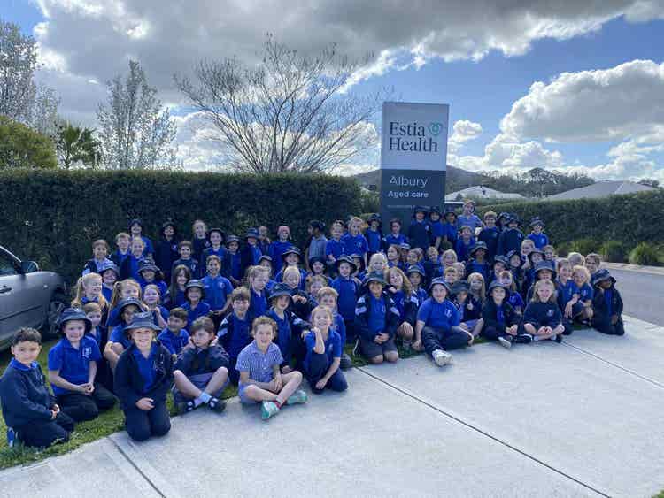 Students sitting in front of Estia Health after their excursion