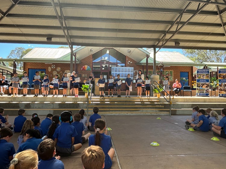 Students standing on stage with certificates at Stage 1 Presentation Day